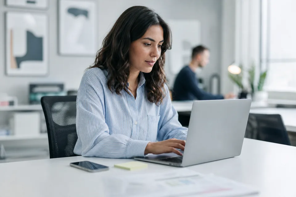Marketing coordinator rewriting a promotional text message on a laptop