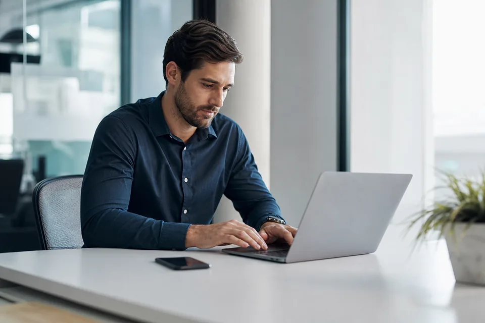 Sales rep answering a customer text on a laptop in a quiet corner of an office